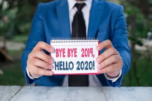 Текст написання слова "Bwell Bye 2019 Hello 2020" бізнес-концепція для прощання з минулим роком і привітання іншого хорошого Чоловік тримає порожній папір з копіювальним простором перед собою . — стокове фото
