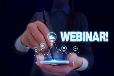 Webinar'ı gösteren not yazma. İş fotoğraf vitrin seminerveya Internet üzerinde yer alan diğer sunum türleri Kadın akıllı cihaz kullanarak sunum sunan resmi iş elbisesi giymek.
