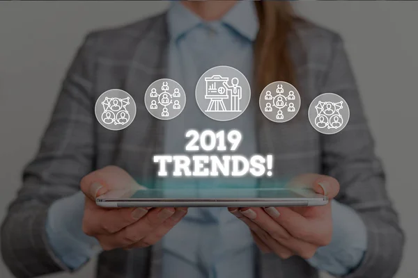 Conceptual hand writing showing 2019 Trends. Business photo text general direction in which something is developing or changing Woman wear work suit presenting presentation smart device.