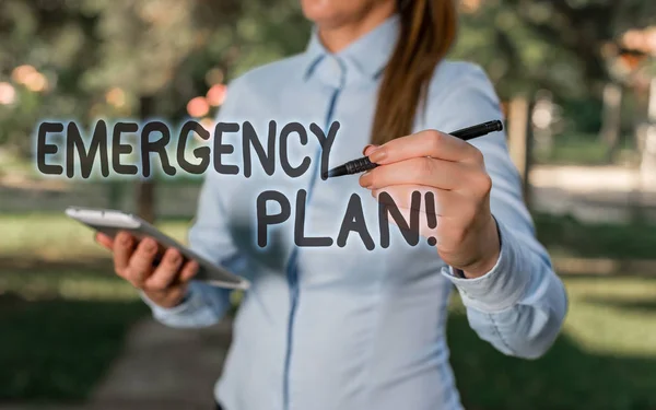 Conceptual hand writing showing Emergency Plan. Business photo text actions developed to mitigate damage of potential events Woman in a blue shirt pointing with her finger into empty space. — Stock Photo, Image