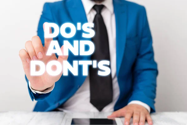 Handwriting text writing Do S Is And Dont S Is. Concept meaning advising Rules or customs concerning some activity Businessman with pointing finger in front of him. — Stock Photo, Image