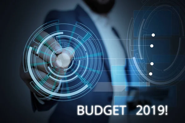 写说明显示2019年预算。商业照片展示本年度收入和支出估计男性穿正式西装演示智能设备. — 图库照片