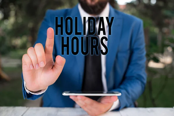 Teks tulisan kata Holiday Hours. Konsep bisnis untuk karyawan menerima dua kali gaji normal mereka selama berjam-jam Pengusaha dengan menunjuk jari di depannya . — Stok Foto