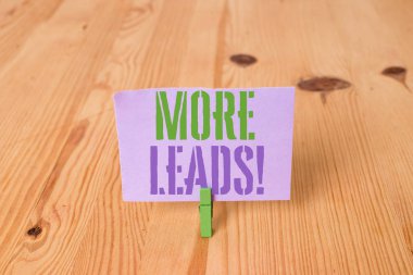 Daha Fazla Müşteri Adayı gösteren not yazma. Ürün veya hizmetler ahşap zemin arka plan yeşil clothespin oluk yuvası ofis içine başlatma tüketici faiz soruşturma vitrine.