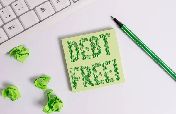 Escritura a mano conceptual mostrando Debt Free. Texto de la foto de negocios no posee ningún dinero a cualquier individuo o empresas Papel de nota verde con lápiz sobre fondo blanco y teclado PC . — Foto de Stock