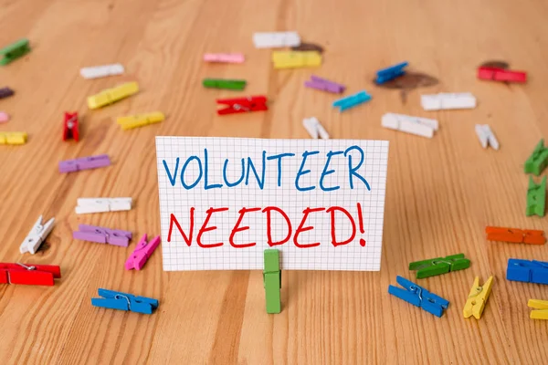 Text sign showing Volunteer Needed. Conceptual photo need work for organization without being paid Colored clothespin papers empty reminder wooden floor background office.