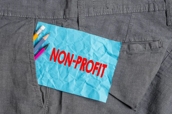 Text sign showing Non Profit. Conceptual photo type of organization that does not earn profits for its owners Writing equipment and blue note paper inside pocket of man work trousers.