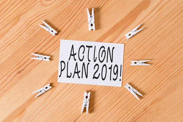 Conceptual hand writing showing Action Plan 2019. Business photo text proposed strategy or course of actions for current year Colored crumpled papers wooden floor background clothespin.