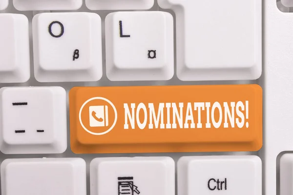 Pisanie notatki przedstawiające nominacje. Business Photo prezentuje akcję nominacji lub stan nominowany do nagrody biała klawiatura PC z papieru notatki powyżej białego tła. — Zdjęcie stockowe