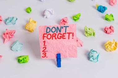 Don T Forget'ı gösteren kavramsal el yazısı. Önemli gerçeği veya detay Hakkında birisi hatırlatmak için kullanılan iş fotoğraf metin Renkli buruşturulmuş kağıt boş hatırlatma beyaz zemin clothespin.