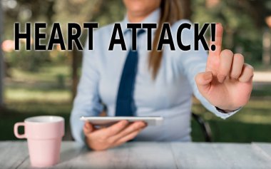Kalp Krizini gösteren kavramsal el yazısı. Ölümle sonuçlanan koroner trombozun ani ortaya çıkması İş fotoğrafı metin Kadın iş adamı masaya oturan ve cep telefonu tutan.
