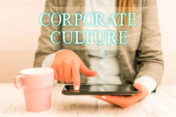 Kézírás szöveg írás testületi kultúra. Koncepció értelmében átható értékek és attitűdök jellemző a társaság üzleti nő ül a mobil telefon és csésze kávét az asztalra. — Stock Fotó