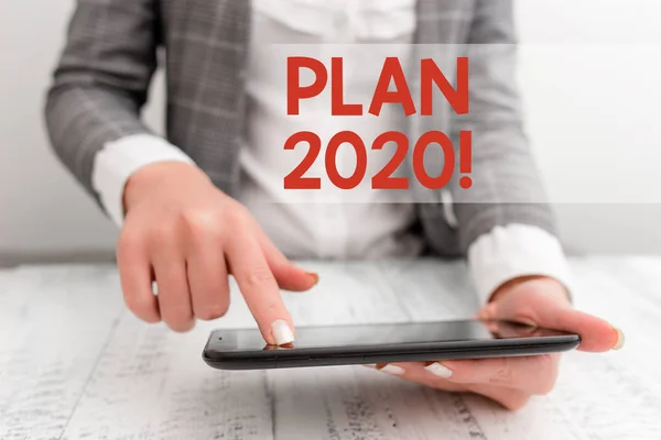 Текст написання слів План 2020. Концепція бізнесу для детальної пропозиції щодо досягнення чогось наступного року Концепція бізнесу з мобільним телефоном в руці . — стокове фото