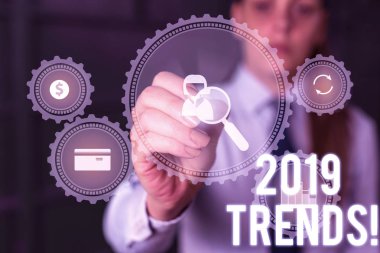 Kelime yazma metni 2019 Trendler. Bir şeyin geliştiği veya değiştiği genel yön için iş konsepti Kadın akıllı cihaz kullanarak sunum sunan resmi iş elbisesi giyer.