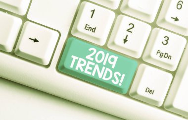 2019 Trendlerini gösteren kavramsal el yazısı. Bir şeyin beyaz arka plan üzerinde not kağıdı yla Beyaz bilgisayar klavyesi geliştirdiği veya değiştirdiği iş fotoğrafı metni genel yönü.