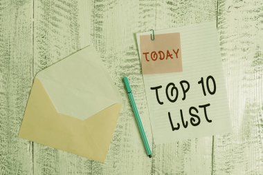 Top 10 Listesi gösteren not yazma. Belirli bir listede on en önemli veya başarılı öğeleri vitrine İş fotoğrafı Zarf boş sayfa yapışkan not tükenmez ahşap arka plan.