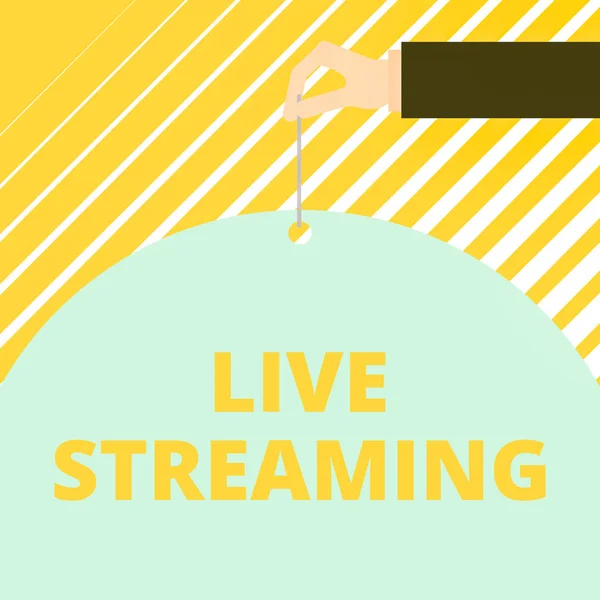 Text sign showing Live Streaming. Conceptual photo Transmit live video coverage of an event over the Internet Man hand hold big half round paper tie string with thumb and index finger.