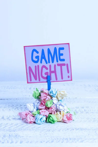 Conceptual hand writing showing Game Night. Business photo text usually its called on adult play dates like poker with friends Reminder pile colored crumpled paper clothespin wooden space.