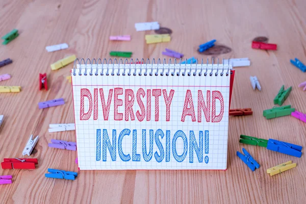 Handwriting text writing Diversity And Inclusion. Concept meaning range huanalysis difference includes race ethnicity gender Colored clothespin papers empty reminder wooden floor background office.