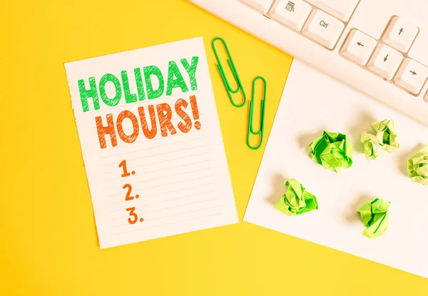 Conceptual hand writing showing Holiday Hours. Business photo text Overtime work on for employees under flexible work schedules Flat lay with copy space white paper with paper clips on the table.
