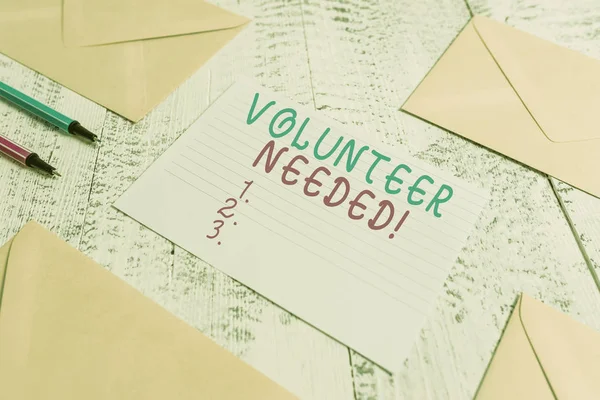 Word writing text Volunteer Needed. Business concept for asking demonstrating to work for organization without being paid Envelopes highlighters ruled paper sheet wooden retro vintage background.