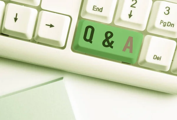 QとA.ビジネス写真を示す概念的な手書き手書きは、質問として定義され、白い背景の上にノート紙で白いPCキーボードに答えます. — ストック写真