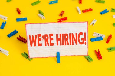 Kavramsal el yazma biz Re Hiring gösteren. Başvuruları gözden geçirme ve aday bulma İş fotoğraf metin süreci Renkli clothespin kağıtları boş hatırlatma sarı zemin ofis.