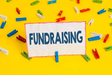 Bağış toplamayı gösteren kavramsal el yazısı. Belirli bir amaç için para toplama veya üreten İş fotoğraf metin hareket Renkli clothespin kağıtları boş hatırlatma sarı zemin ofis.