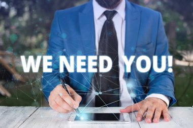 El yazısı metni Sana İhtiyacımız Var. Kavram belirli bir iş için birlikte çalışmak ya da hedef Erkek insan giyim resmi iş elbisesi akıllı cihaz kullanarak sunum sunan birinden soran anlamı.