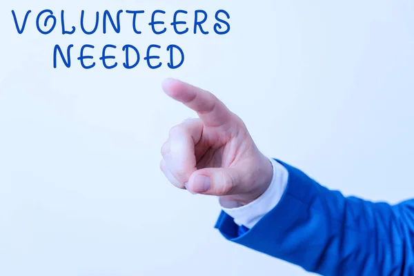 Word writing text Volunteers Needed. Business concept for need work or help for organization without being paid Isolated hand pointing with finger. Business concept pointing finger.