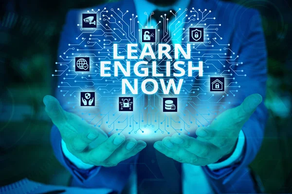 Word writing text Learn English Now. Business concept for gain or acquire knowledge and skill of english language Male human wear formal work suit presenting presentation using smart device.