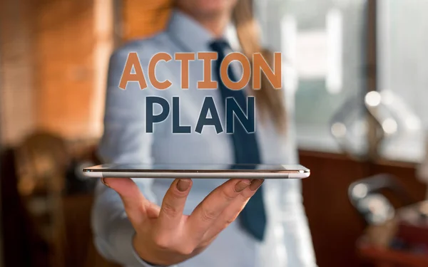 Writing note showing Action Plan. Business photo showcasing detailed plan outlining actions needed to reach goals or vision Blurred woman in the background pointing with finger in empty space. — Stock Photo, Image