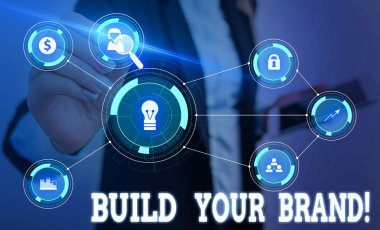 Markanızı Oluştur'u gösteren not yazma. İş fotoğraf vitrin oluşturur veya müşteri bilgi ve ürün görüşlerini geliştirir Kadın akıllı cihaz kullanarak sunum sunan resmi iş elbisesi giymek.