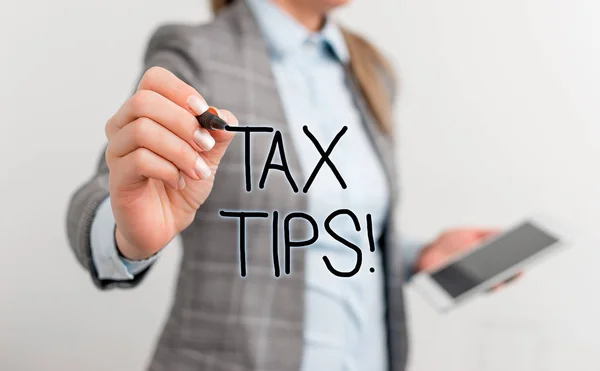 Text sign showing Tax Tips. Conceptual photo compulsory contribution to state revenue levied by government Business woman pointing in empty space with pen and mobile phone. — Stock Photo, Image