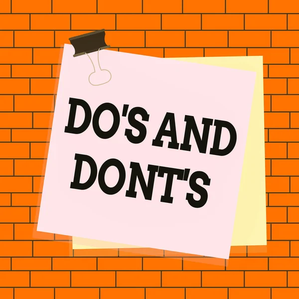 Text sign showing Do S And Dont S. Conceptual photo Rules or customs concerning some activity or actions Paper stuck binder clip colorful background reminder memo office supply.