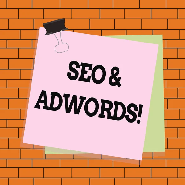 Szöveges jel mutatja SEO és az AdWords. Konceptuális fotó ezek fő eszközök összetevői Search Engine Marketing papír megragadt iratgyűjtő klip színes háttér emlékeztető iroda ellátás. — Stock Fotó