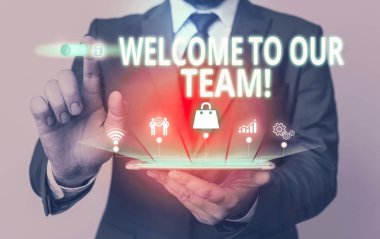 Ekibimize Hoş Geldiniz'i gösteren bir not yazıyorum. Takım arkadaşlarınıza başka bir gösteri tanıtan İş fotoğraf vitrin erkek sunum akıllı cihaz sunan resmi takım giymek.