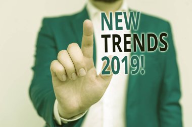 Kelime yazma metni Yeni Trendler 2019. Bir şey boş alanda parmak ile işaret mavi suit ve beyaz gömlek İşadamı geliştiriyor genel yön için İş kavramı.