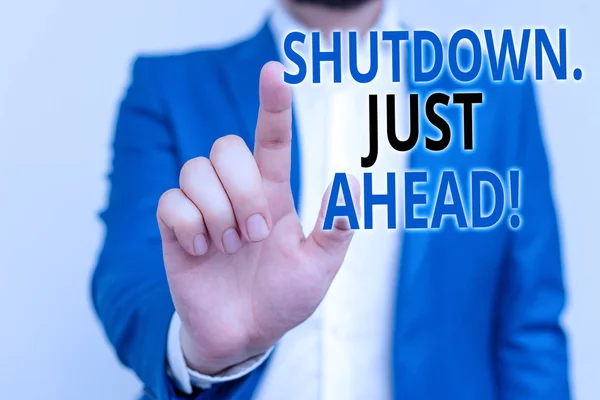 Word writing text Shutdown Just Ahead. Business concept for closing factory business either short time or forever Businessman in blue suite and white shirt pointing with finger in empty space. — ストック写真