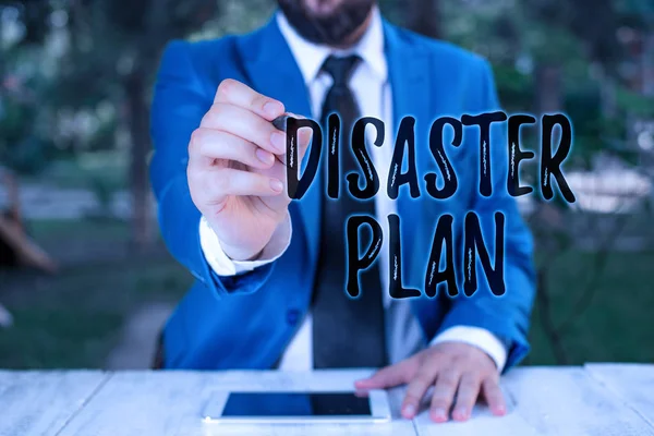 Writing note showing Disaster Plan. Business photo showcasing Respond to Emergency Preparedness Survival and First Aid Kit Businessman holds pen and points into copy space.