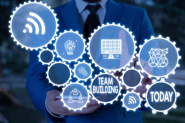 Text sign showing Team Building. Conceptual photo various types of activities used to enhance social relations Male human wear formal work suit presenting presentation using smart device. — Stock Photo, Image