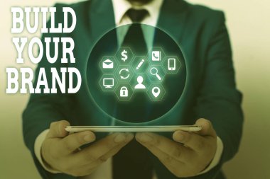 Markanızı İnşa Edin 'i gösteren bir not yazıyorum. Reklam kampanyaları kullanarak marka eşitliğini arttıran iş fotoğrafları..