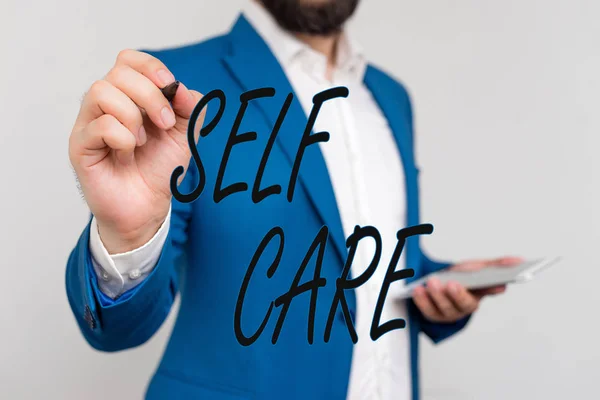 Znak tekstowy przedstawiający Self Care. Koncepcyjne zdjęcie praktyka podejmowania działań w celu poprawy jeden s jest właścicielem zdrowia biznesmen w Blue Suite i biała koszula wskazując palcem w pustej przestrzeni. — Zdjęcie stockowe