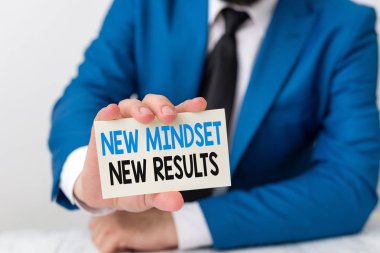 El yazısı metin yazma Yeni Mindset Yeni Sonuçlar. Kavram anlamı engeller başarıya ulaşmak için fırsatlar Adam önünde kopya alanı ile boş kağıt tutar Uzay.