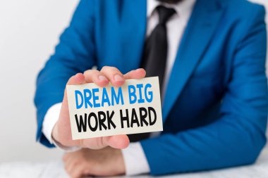 El yazısı metin dream big work hard yazma. Kavram anlamı Kendinize inanın ve hayallerini ve hedeflerini takip edin İnsan önünde kopya alanı olan boş bir kağıt tutar Uzay.