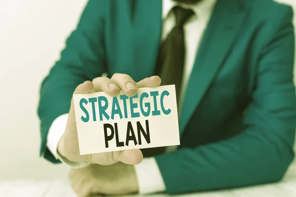 Handwriting text writing Strategic Plan. Concept meaning a systematic process of envisioning a desired future Man holds empty paper with copy space in front of him Space. — Stock Photo, Image