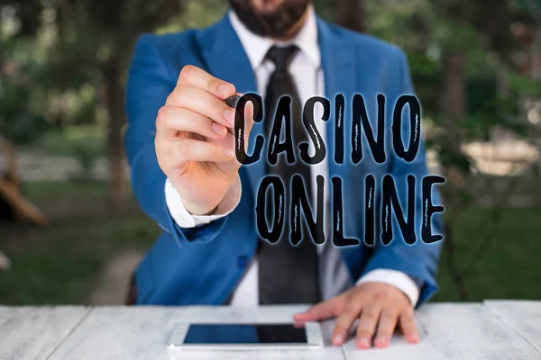 Note d'écriture montrant Casino en ligne. Photo d'affaires mettant en vedette le jeu de poker sur ordinateur pari royal Lotto enjeux élevés Homme d'affaires tient stylo et des points dans l'espace de copie . — Photo