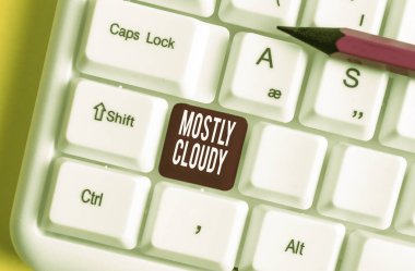 Çoğunlukla Bulutlu yazma el yazısı metin. Kavram anlamı Shadowy Vaporous Foggy Fluffy Bulutlu Bulutlar Skyscape Beyaz pc klavye beyaz arka plan tuş kopyalama alanı üzerinde boş not kağıdı ile.