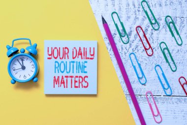 El yazısı metin Your Daily Routine Matters. Kavram anlamı uygulama düzenli sabit sırayla şeyler yapıyor Not defteri marker kalem renkli kağıt levha klipleri çalar saat ahşap arka plan.
