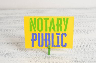 Noter Likit'i gösteren metin işareti. Kavramsal fotoğraf Yasallık Dokümantasyon Yetki Belgesi Sözleşme Yeşil clothespin beyaz ahşap arka plan renkli kağıt hatırlatma ofis kaynağı.